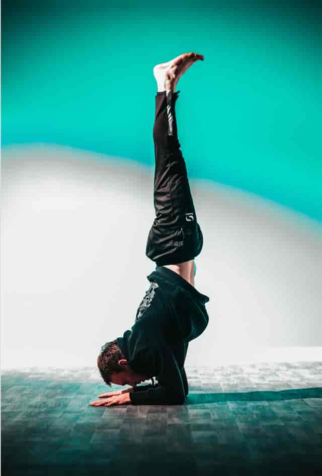 Dynamic performer in handstand at Graystone Action Sports Academy yoga studio event.