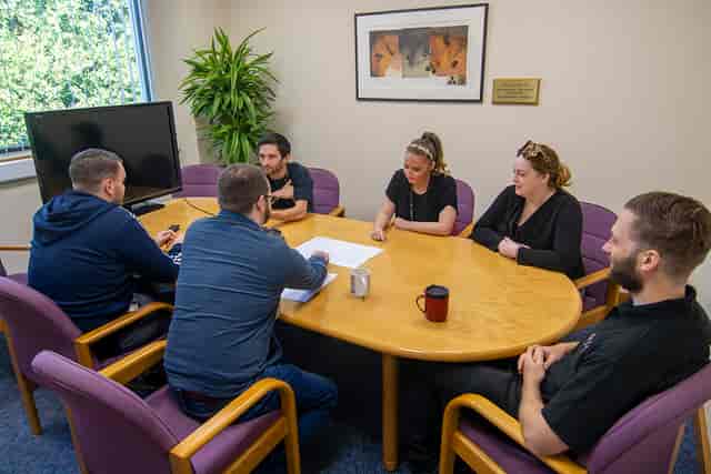 "Bonner Suite meeting with six professionals collaborating around a round table."