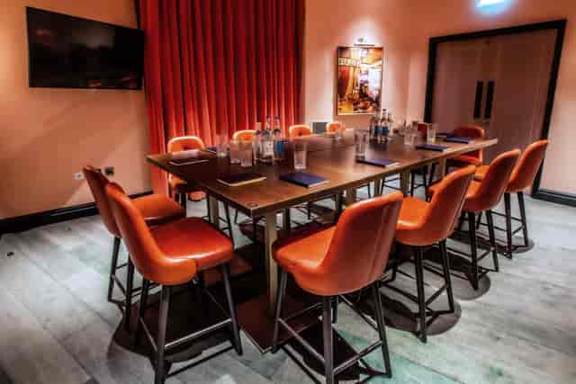 Rose Private Room at Puttshack Bank, featuring a large table for meetings and gatherings.