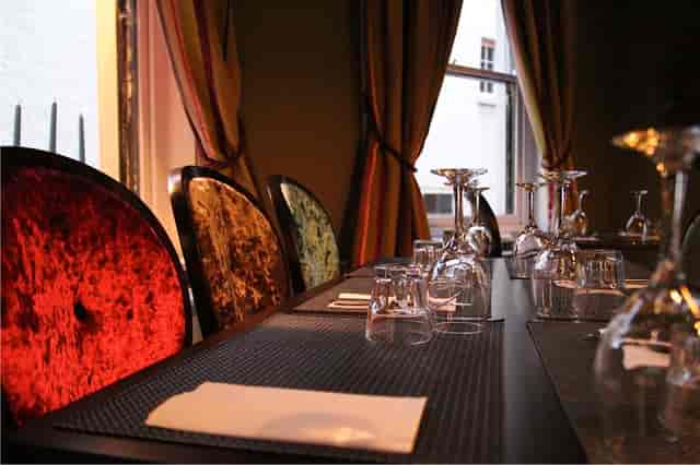 Alice in Wonderland Room dining table with vibrant chairs, ideal for upscale events.