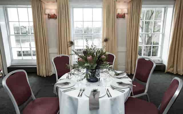 Elegant round table in Commodores Room, perfect for intimate meetings and events.