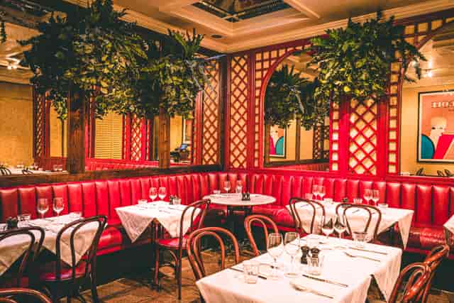 Private room in Palm Court Brasserie with red banquettes, ideal for corporate events and gatherings.
