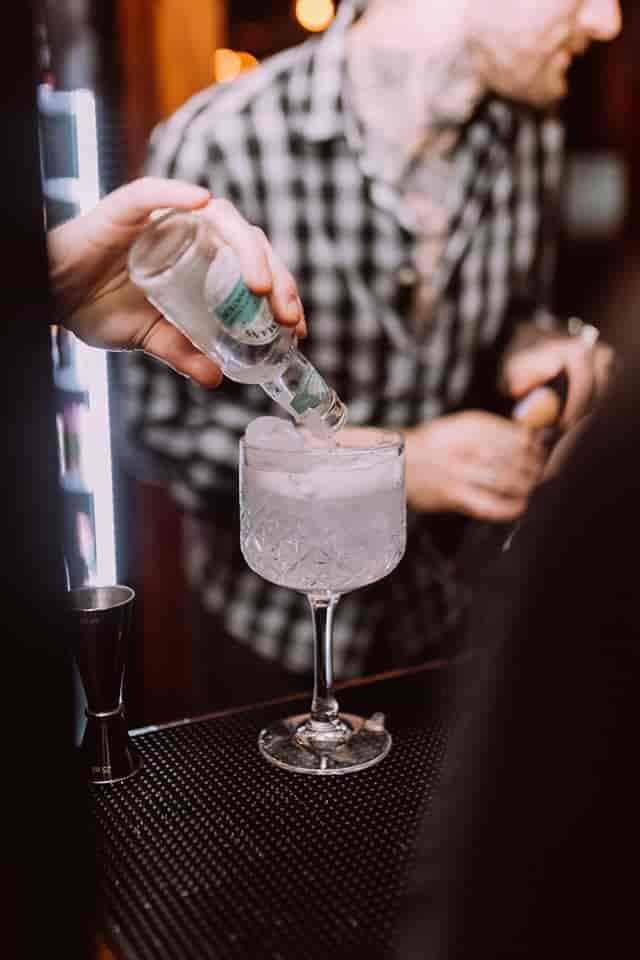 Bartender crafting a cocktail at The Fireplace, ideal for event catering and mixology.
