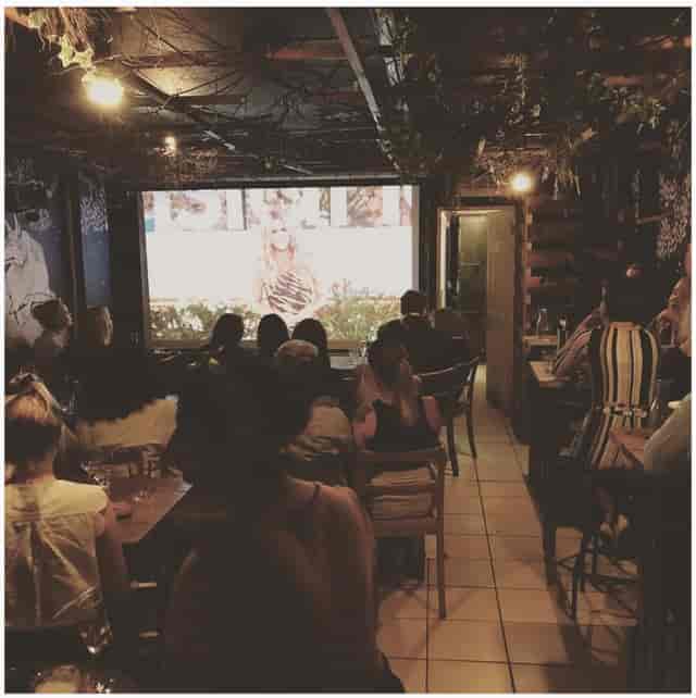 Cozy BATCH Cocktail Bar set for a screening event with dim lighting and rustic decor.