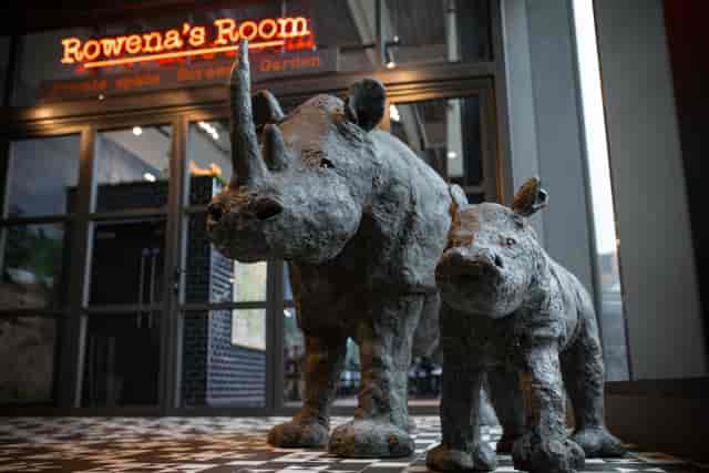 Rowena's Room entrance with rhinoceros sculptures, ideal for events and gatherings.