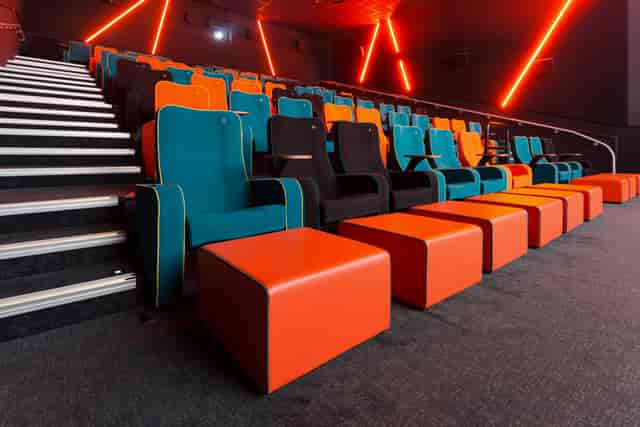 Modern cinema auditorium with teal and orange seating for engaging film screenings.