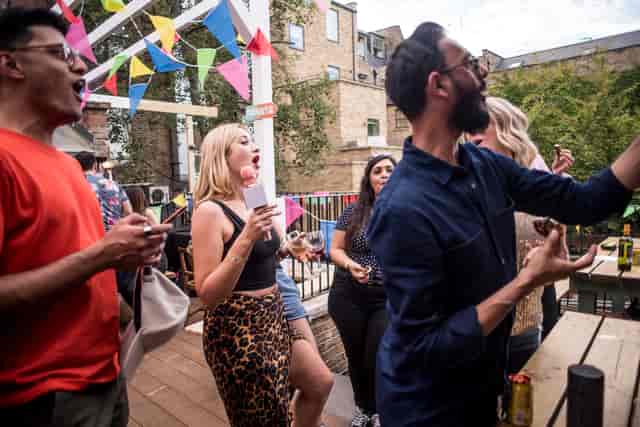 Lively outdoor team-building event at Abbey Tavern with colorful bunting and engaged attendees.