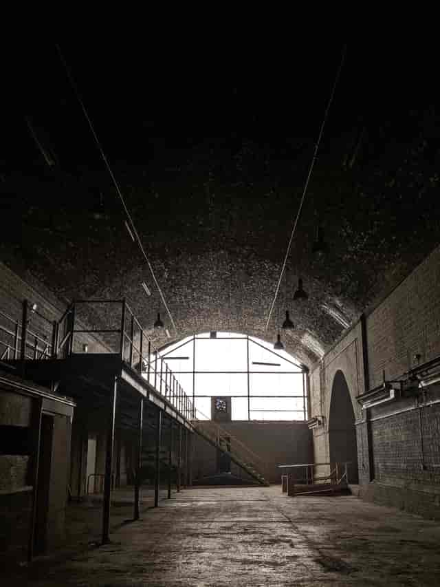 Spacious industrial venue with arched ceiling, perfect for creative events and gatherings.
