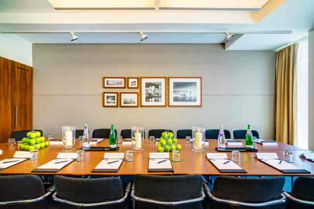 Meeting room with wooden table, notepads, and apples for corporate events.