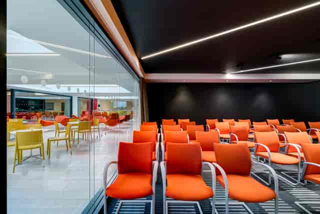 Modern meeting space in Apex City of Bath Hotel with vibrant orange seating for workshops.