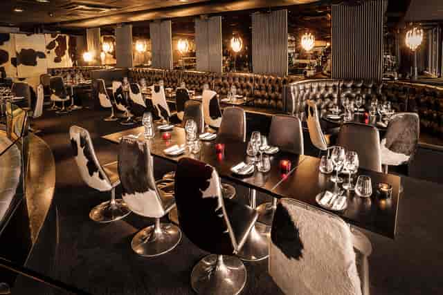 Stylish dining space at Gaucho Canary Wharf with cow-themed decor, perfect for events.