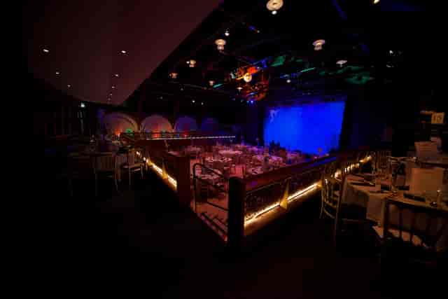 "Elegant dinner event space in The TabernacleW11 with ambient lighting and stage setup."