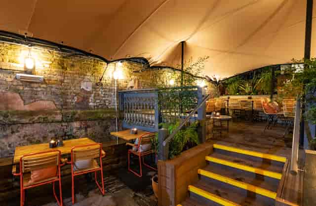 Charming outdoor event space with warm lighting for intimate gatherings and meetings.