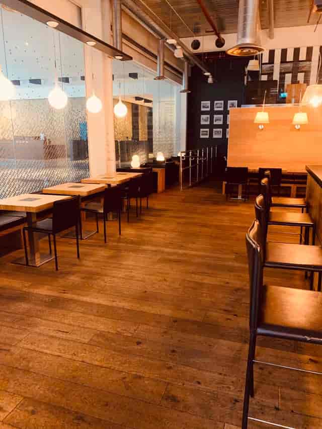 Modern venue with wooden flooring, ideal for meetings and networking events.