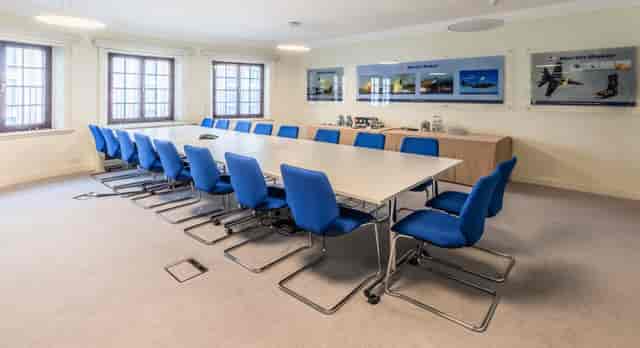 Modern conference room with ergonomic blue chairs for corporate events and meetings.