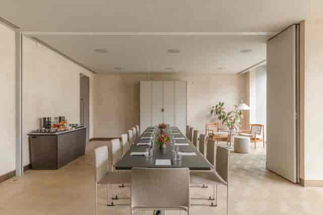 Modern meeting room with long table, natural light for corporate events and gatherings.