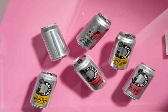 Vibrant beverage cans on pink backdrop for events and gatherings at Rhapsody Studio.