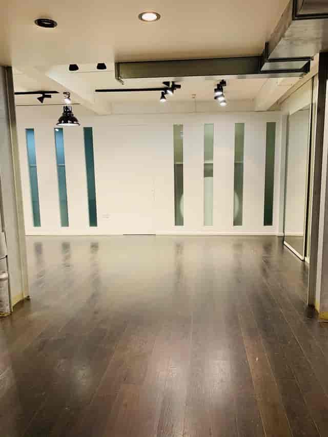 Versatile event space with polished wooden floor in Fitzrovia, ideal for meetings and gatherings.