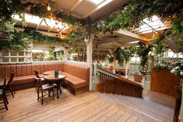 "Elegant event space with greenery and warm lighting for intimate gatherings and networking."