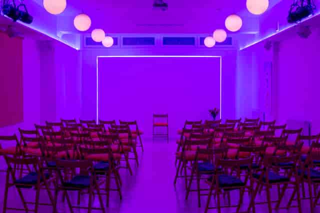 Modern event space at Hridaya Studio with purple lighting for workshops and meetings.