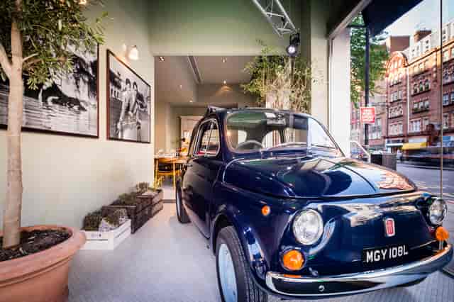 Stylish TOZI Restaurant bar with vintage car, perfect for creative events and product launches.
