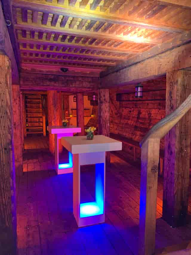 Rustic event space in The Golden Hinde with wooden beams, ideal for social gatherings.
