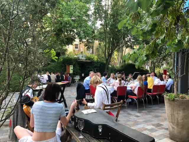 Outdoor event setup at Italo Delicatessen with greenery, perfect for networking gatherings.