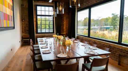 Private dining room with long wooden table, perfect for corporate meetings and events.