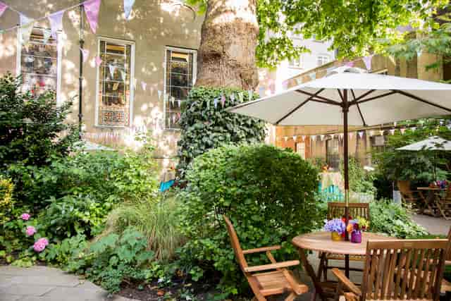Summer party venue at Stationers' Hall with lush greenery and festive bunting.