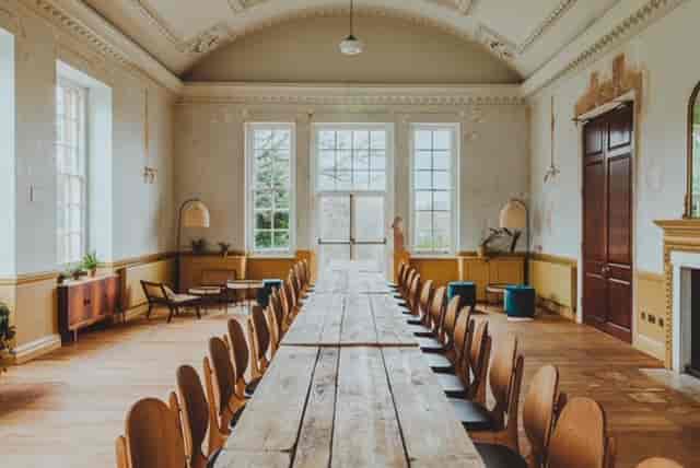 Spacious meeting room with wooden table, ideal for collaborative discussions and events.