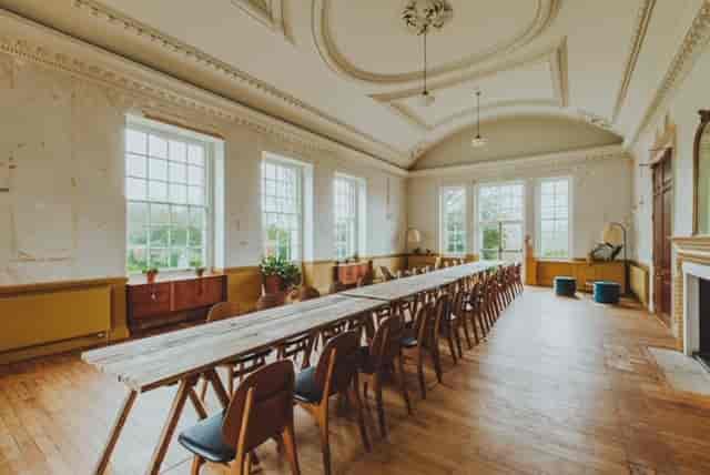 Spacious meeting room with large windows, ideal for workshops and discussions.