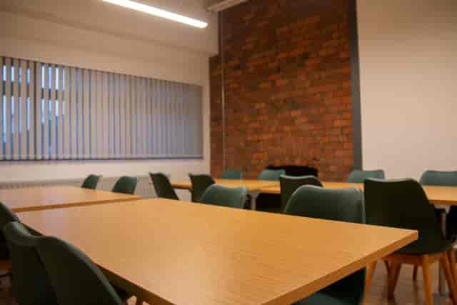 Versatile meeting space with exposed brick wall for creative brainstorming and events.