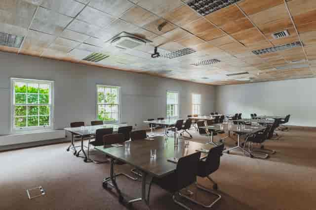 Versatile meeting space with natural light, ideal for workshops and seminars.