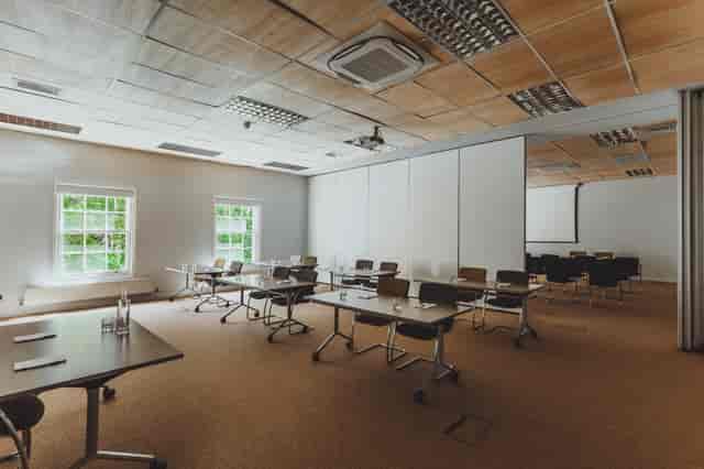 Versatile meeting room with movable furniture, ideal for workshops and corporate events.