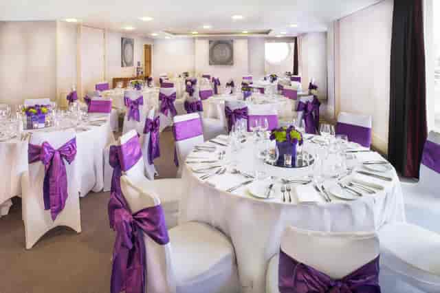 Bridges Suite at Chelsea Harbour Hotel, elegant event space with round tables and purple sashes.