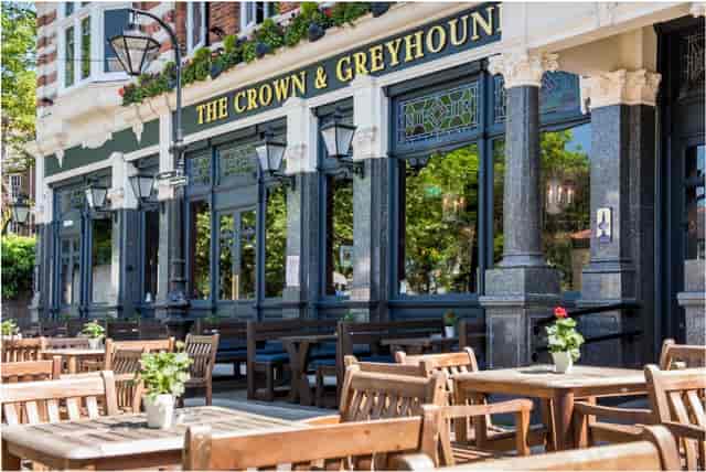 Charming pub façade with outdoor seating for casual meetings and networking events.