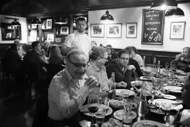 Lively dining event at Goodman Mayfair with elegantly set tables and warm ambiance.