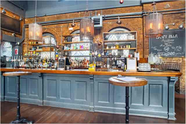 Stylish bar area with exposed brick, perfect for networking events and cocktail receptions.