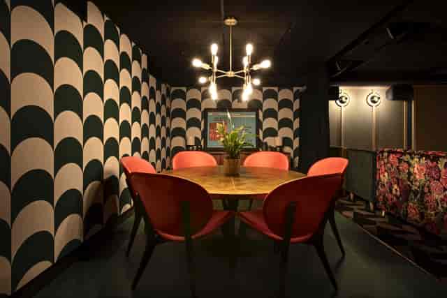 "Stylish round table meeting space with red chairs at Everyman Broadgate for events"