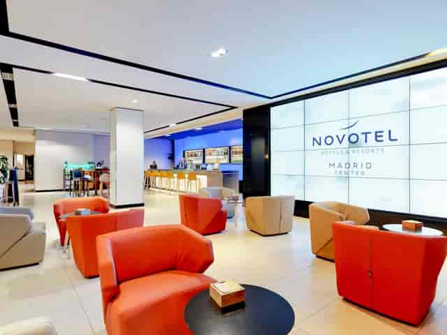 Modern hotel lobby with digital display, ideal for meetings and networking events.