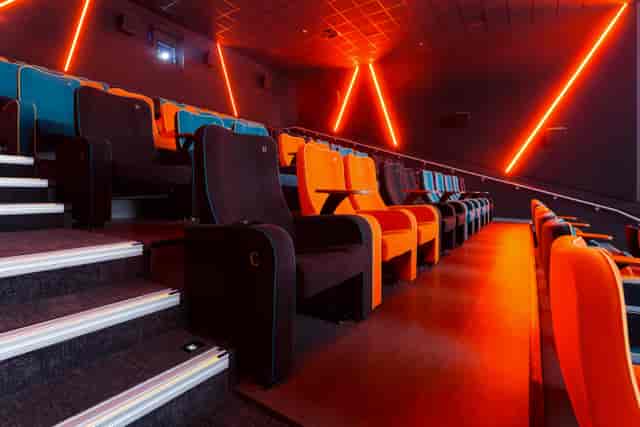 Modern cinema auditorium with vibrant orange and blue seating for film screenings and events.