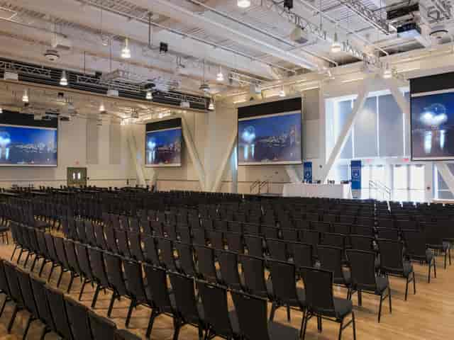 Great Hall in The Nest Vancouver, spacious conference venue with black chairs and stage.