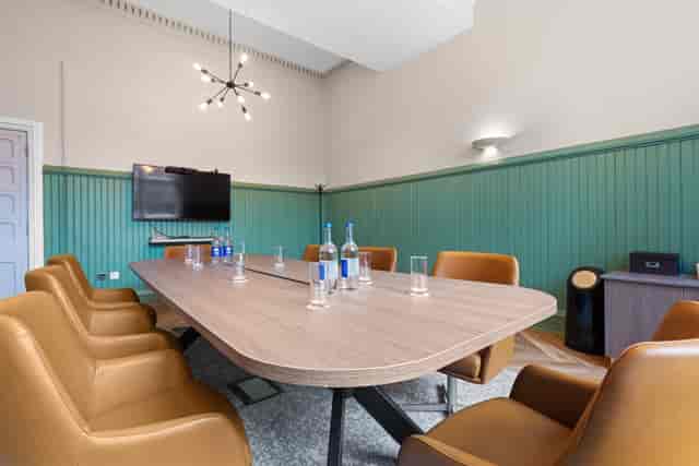 Modern meeting room with wooden table and leather chairs at St Martins House Conference Centre.