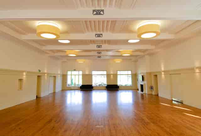 Spacious function room with polished floors for conferences and social gatherings.