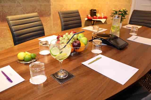 Hyde Suite meeting room at Mercure London, featuring a polished wooden table and refreshments.