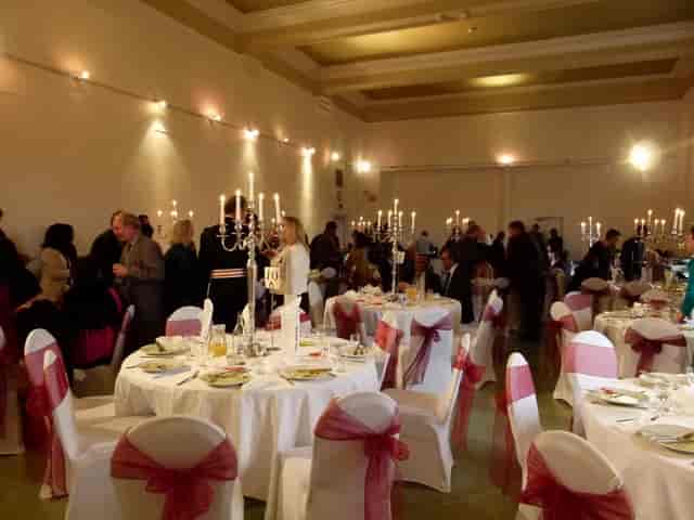Indus Hall at Kala Sangam: elegant event space with white linens and pink sashes.