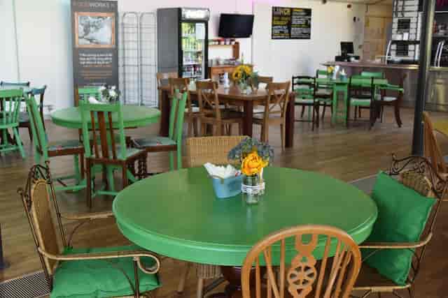 Rooftop Cafe at Kala Sangam: vibrant meeting space with green tables for workshops.