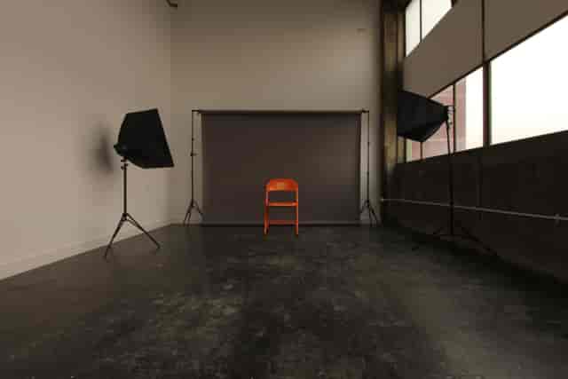 Minimalist meeting venue with orange chair, ideal for interviews and events.