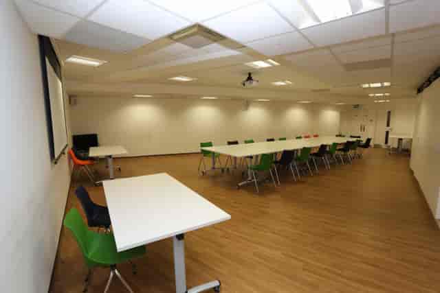 Main hall in Chinese Community Centre with colorful chairs, perfect for workshops and meetings.