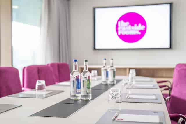 Modern Boardroom One with sleek table and vibrant pink chairs for professional meetings.